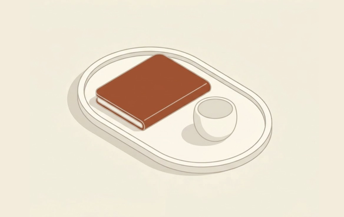 Minimalist illustration of a brown closed book and a white cup on an oval white tray.